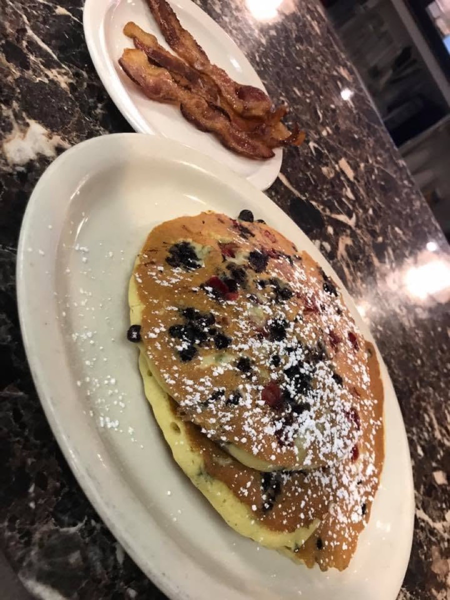 Stack of homemade blueberry pancakes with bacon
